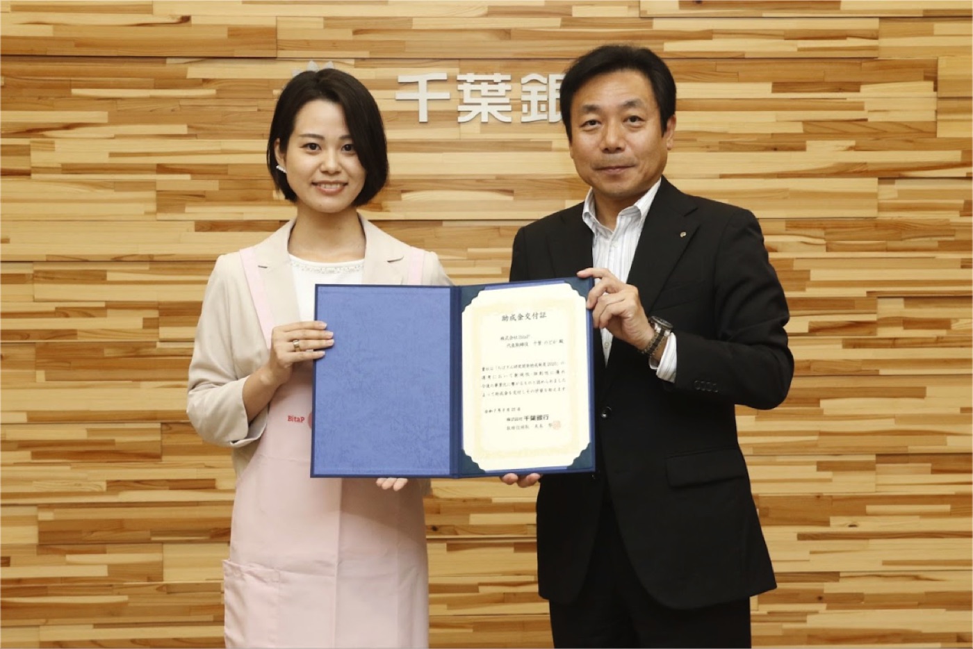 ちばぎん研究開発助成制度2025の助成金交付証を受け取る様子
